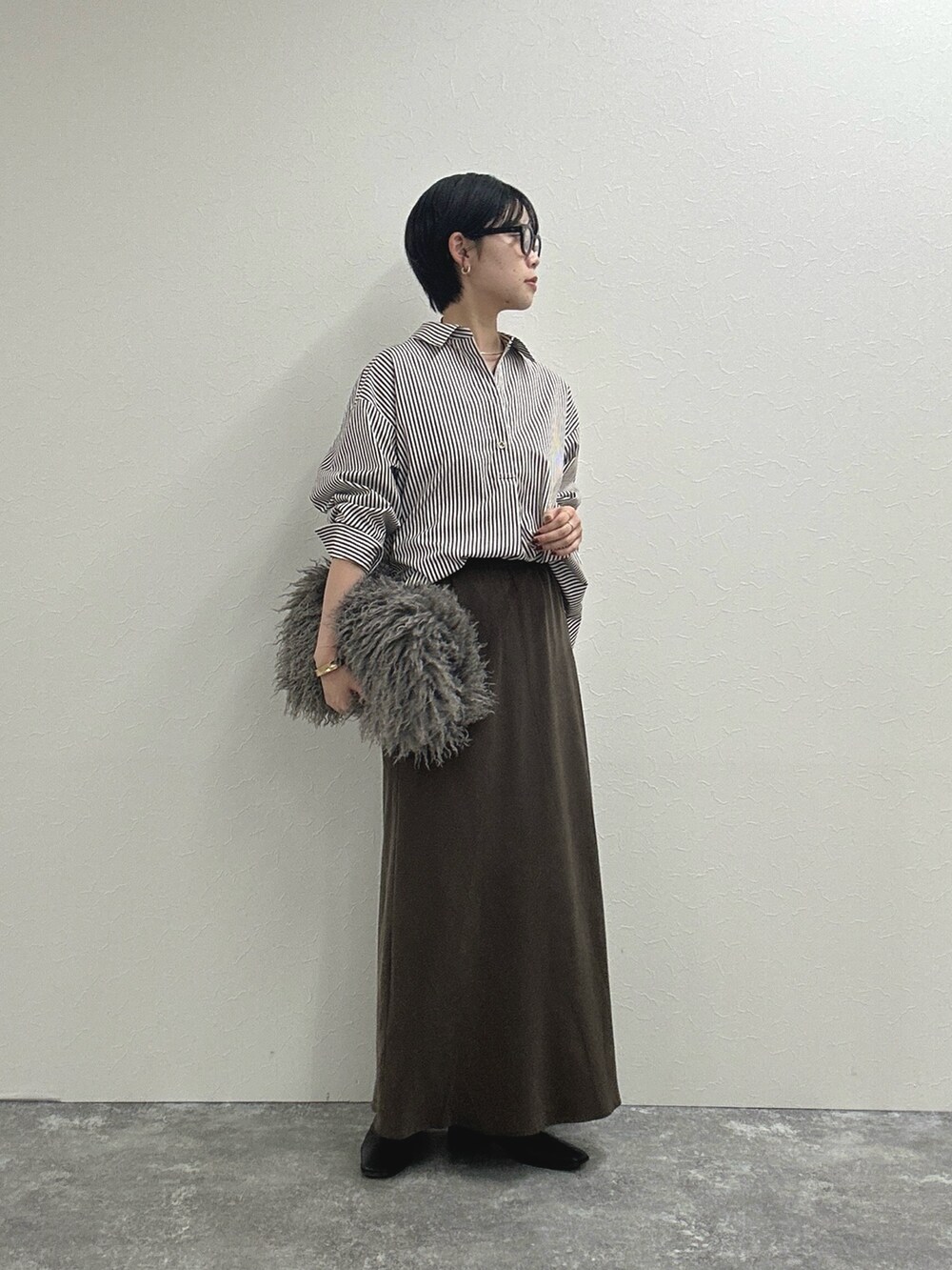 ブラウン系のシャツ/ブラウス、ブラウン系のスカート、ベージュ系のショルダーバッグを着用したレディースの秋コーディネートの4枚目の写真