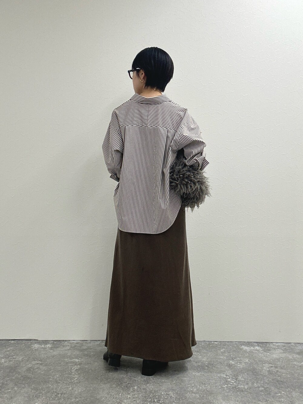 ブラウン系のシャツ/ブラウス、ブラウン系のスカート、ベージュ系のショルダーバッグを着用したレディースの秋コーディネートの6枚目の写真
