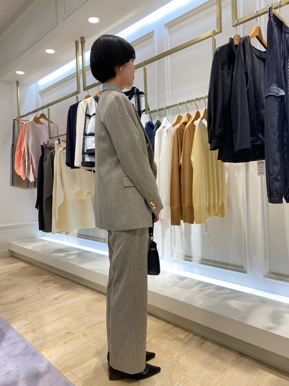 ベージュ系のテーラードジャケット、ブルー系のシャツ/ブラウス、ベージュ系のその他パンツを着用したレディースの秋コーディネートの2枚目の写真