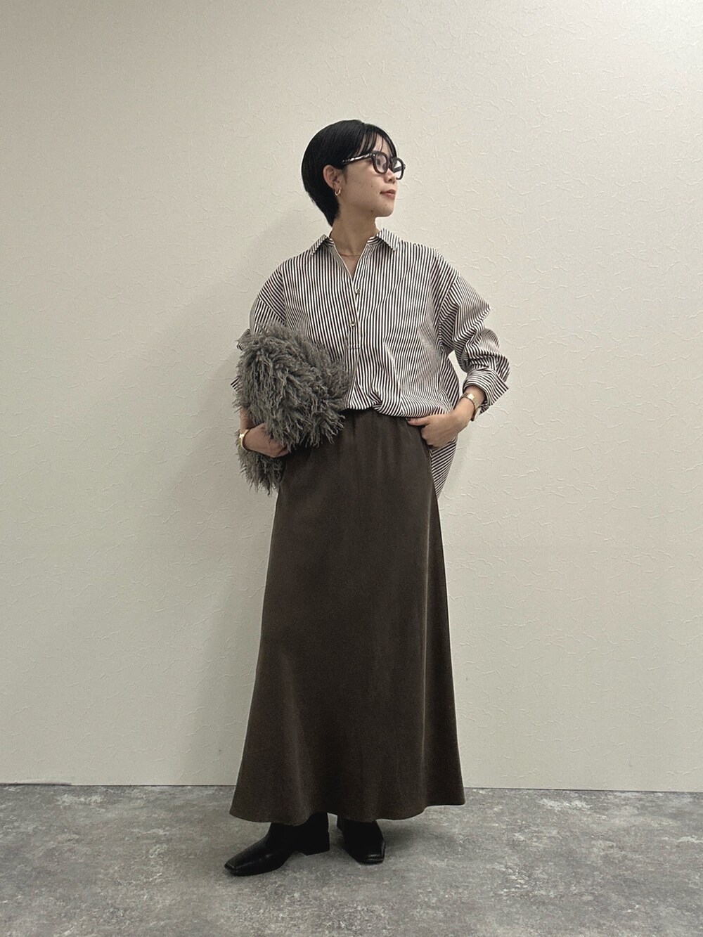ブラウン系のシャツ/ブラウス、ブラウン系のスカート、ベージュ系のショルダーバッグを着用したレディースの秋コーディネートの3枚目の写真