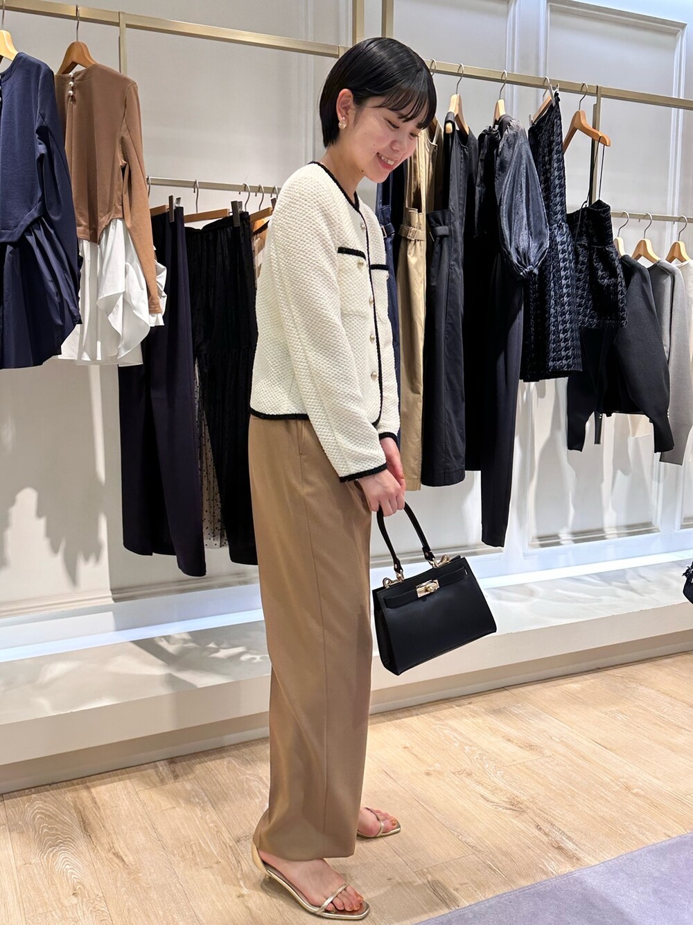 ホワイト系のノーカラージャケット、イエロー系のその他パンツ、ブラック系のショルダーバッグを着用したレディースの秋コーディネートの2枚目の写真