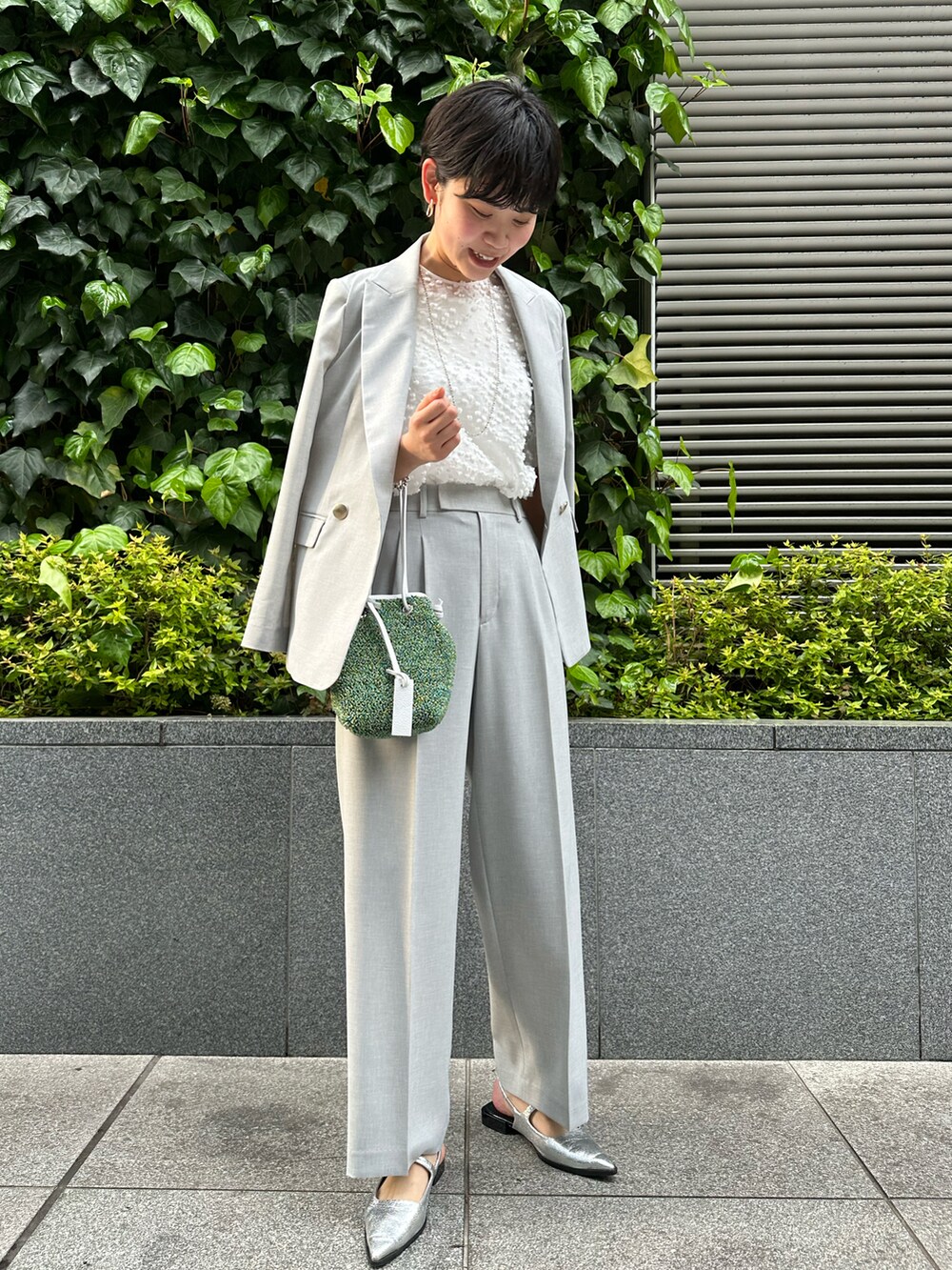 ホワイト系のシャツ/ブラウス、グレー系のその他パンツ、グレー系のテーラードジャケットを着用したレディースの春コーディネートの4枚目の写真