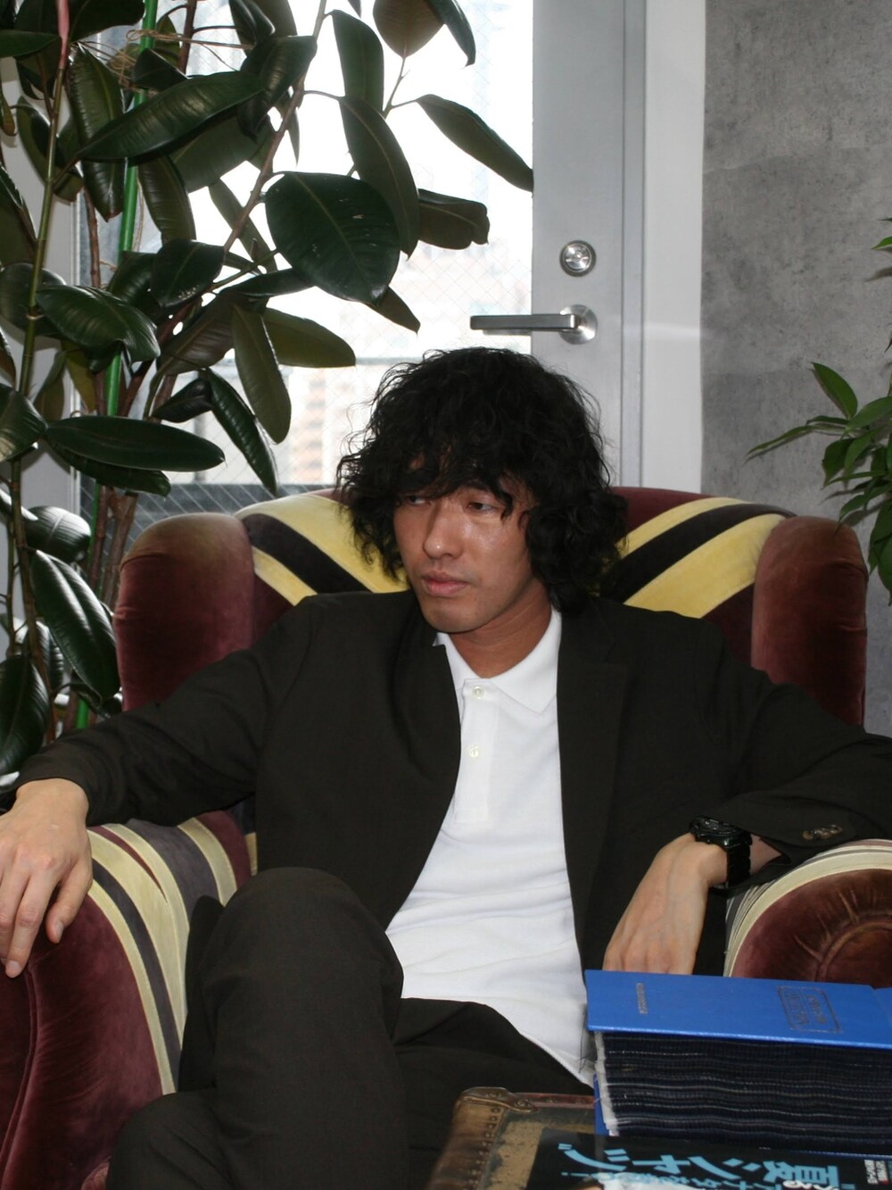 ブラウン系のテーラードジャケット、ホワイト系のポロシャツ、ブラウン系のスラックスを着用したメンズの夏コーディネートの3枚目の写真