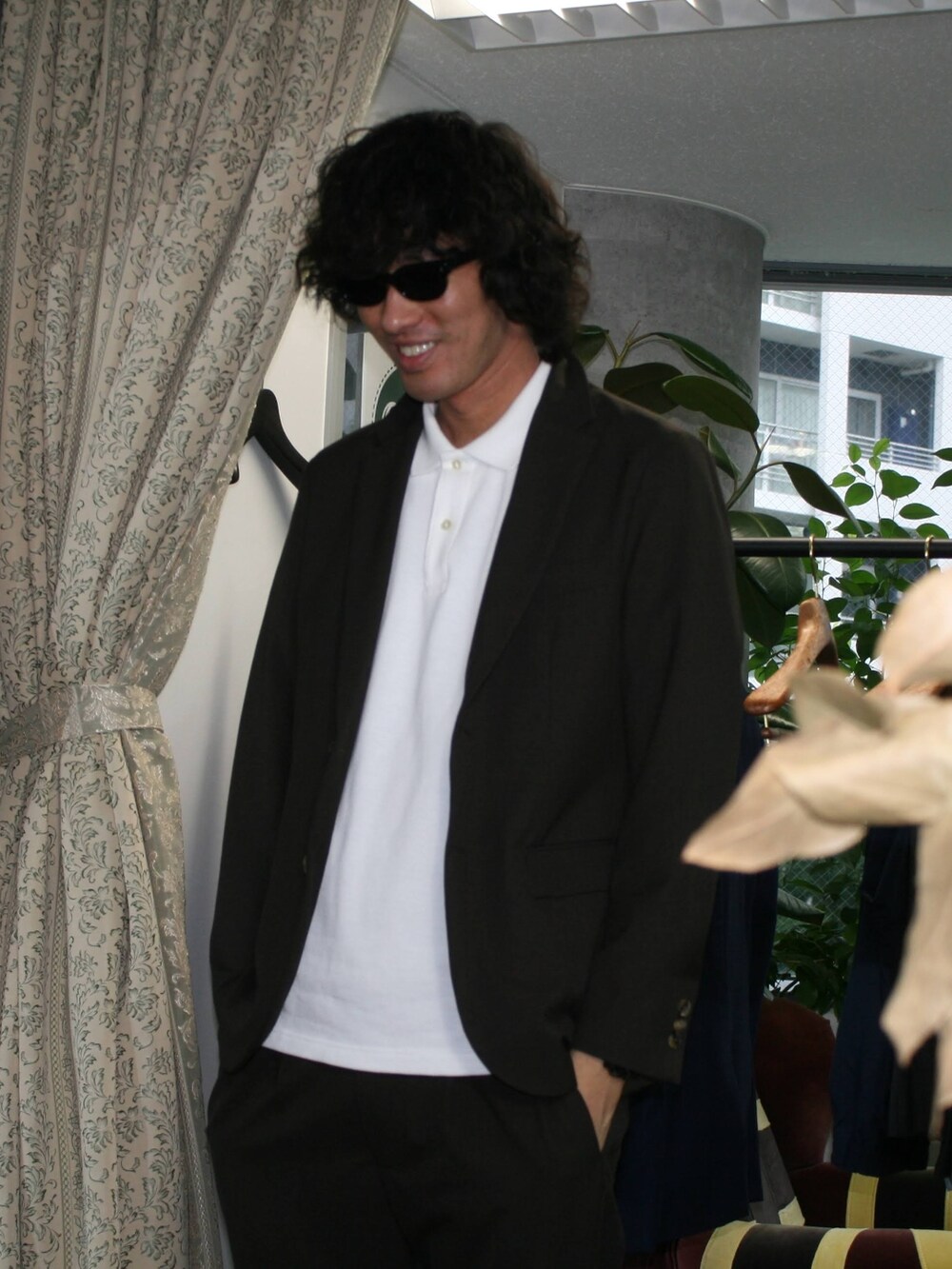 ブラウン系のテーラードジャケット、ホワイト系のポロシャツ、ブラウン系のスラックスを着用したメンズの夏コーディネートの4枚目の写真