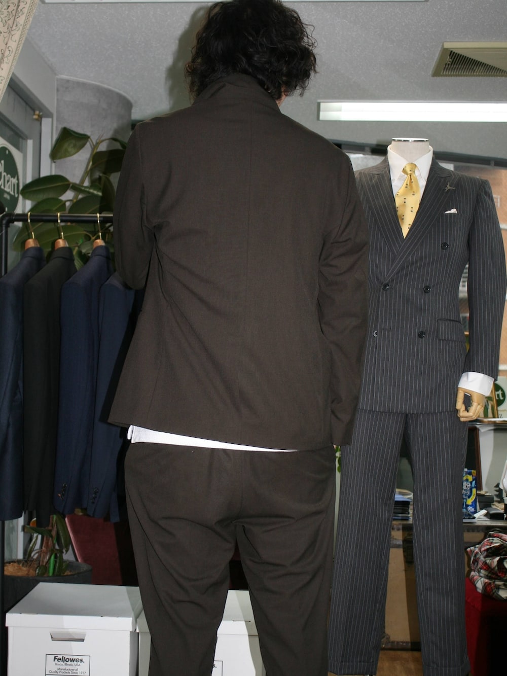 ブラウン系のテーラードジャケット、ホワイト系のポロシャツ、ブラウン系のスラックスを着用したメンズの夏コーディネートの2枚目の写真