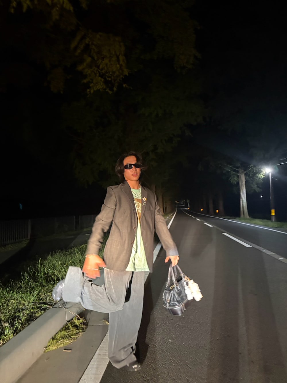 グレー系のテーラードジャケット、グレー系のスラックス、ブラック系のショルダーバッグを着用したメンズの秋コーディネートの2枚目の写真