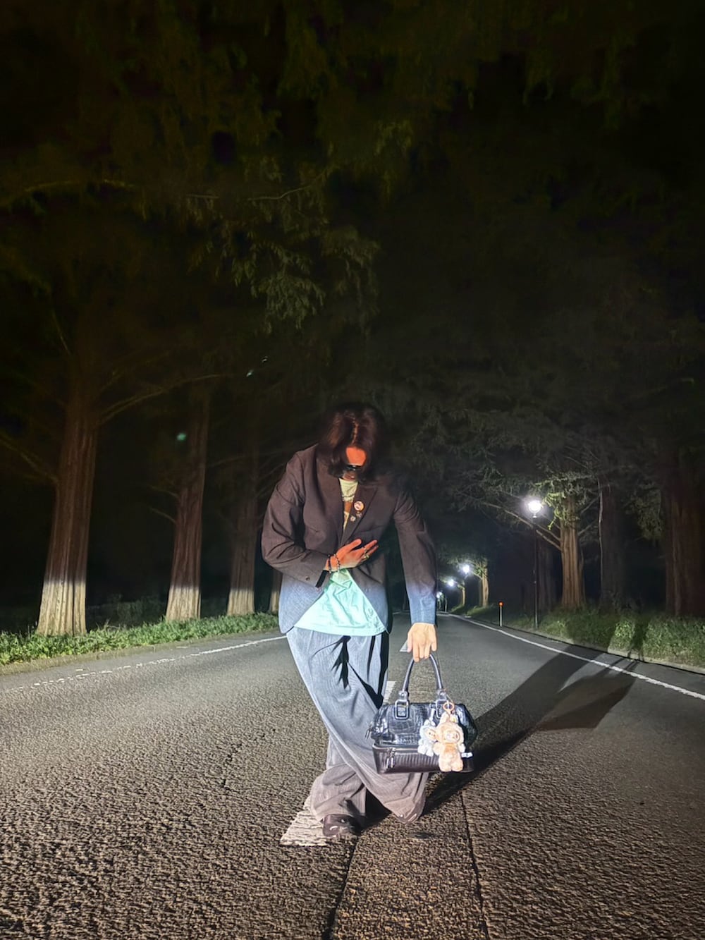 グレー系のテーラードジャケット、グレー系のスラックス、ブラック系のショルダーバッグを着用したメンズの秋コーディネートの3枚目の写真