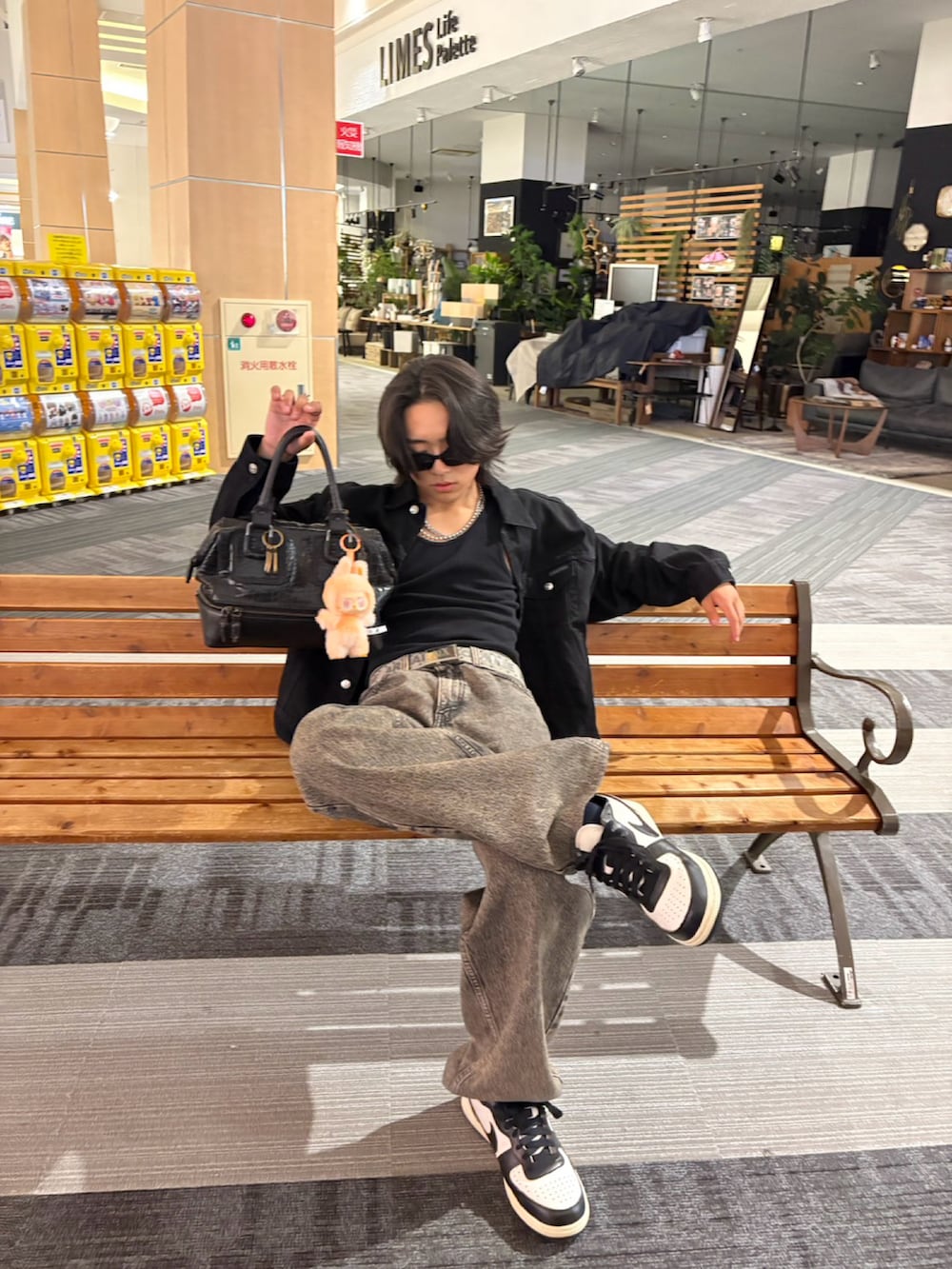 ブラック系のデニムジャケット、グレー系のデニムパンツ、ブラック系のスニーカーを着用したメンズの秋コーディネートの3枚目の写真