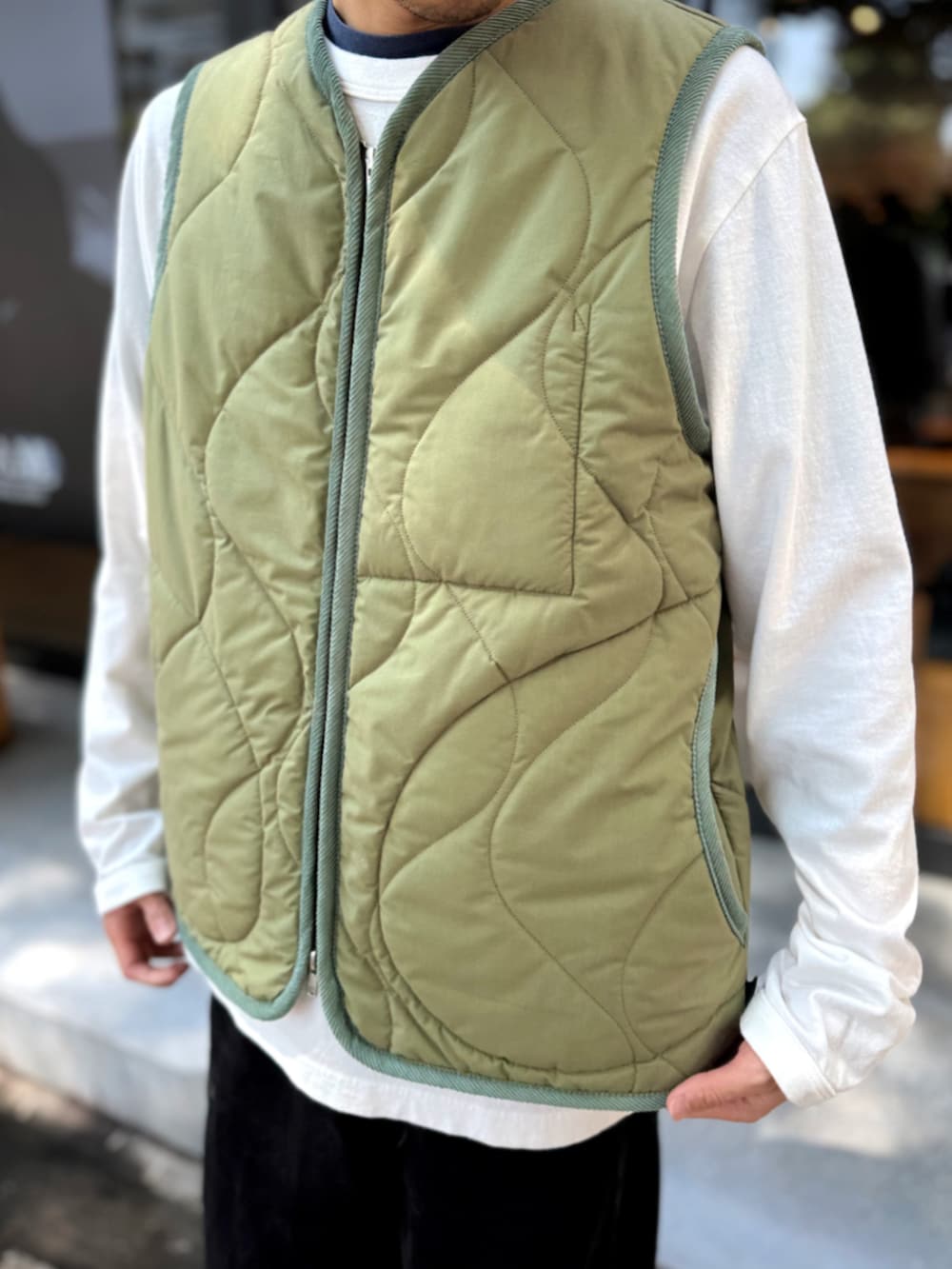 グリーン系のベストを着用したメンズの秋コーディネートの3枚目の写真