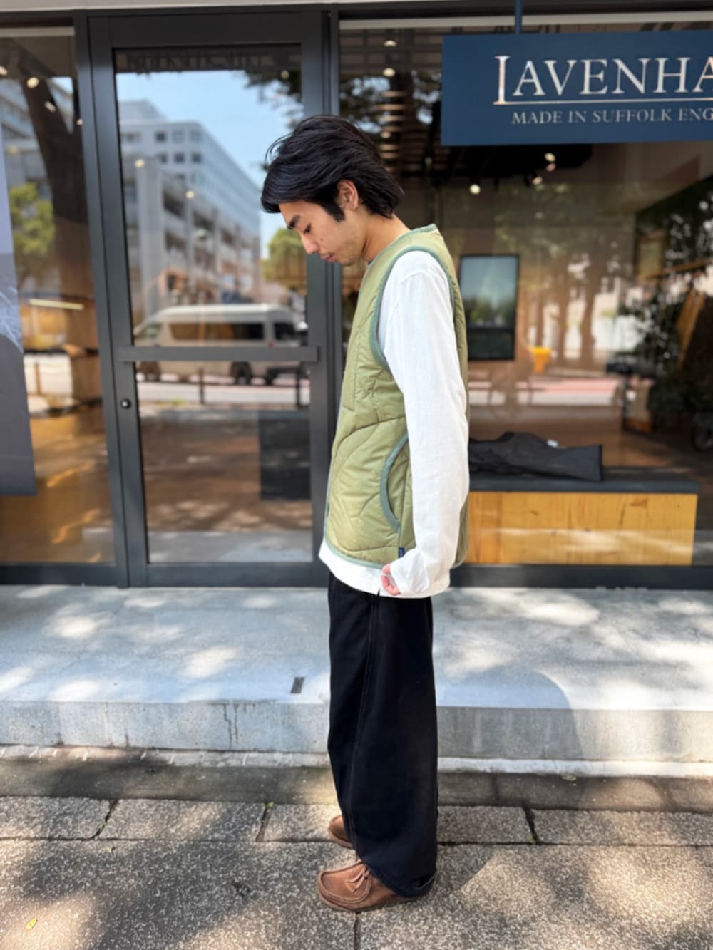 グリーン系のベストを着用したメンズの秋コーディネートの2枚目の写真