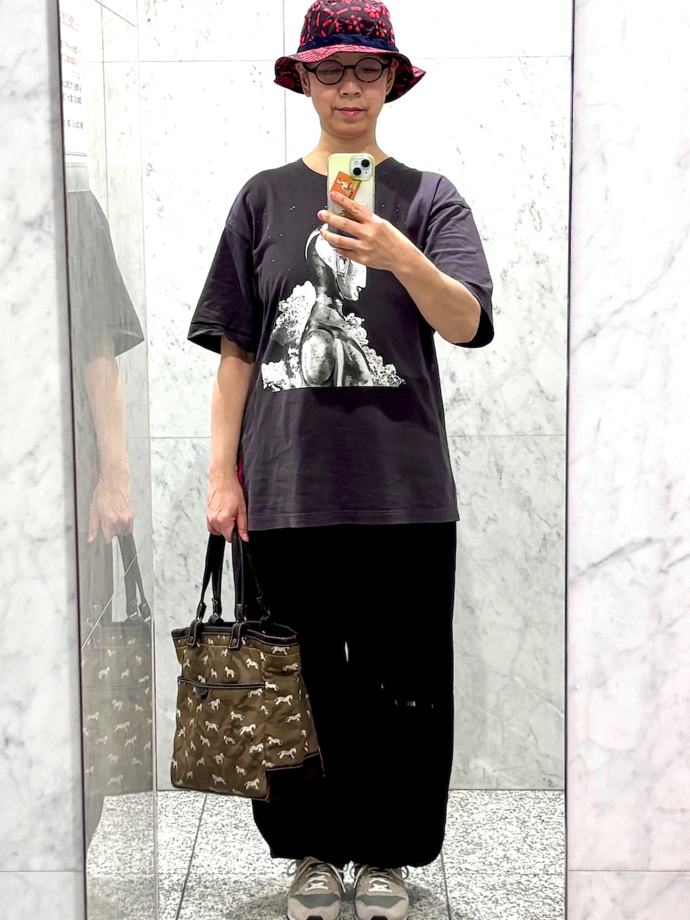 ブラック系のTシャツ/カットソー、グレー系のスニーカーを着用したレディースの春コーディネートの2枚目の写真
