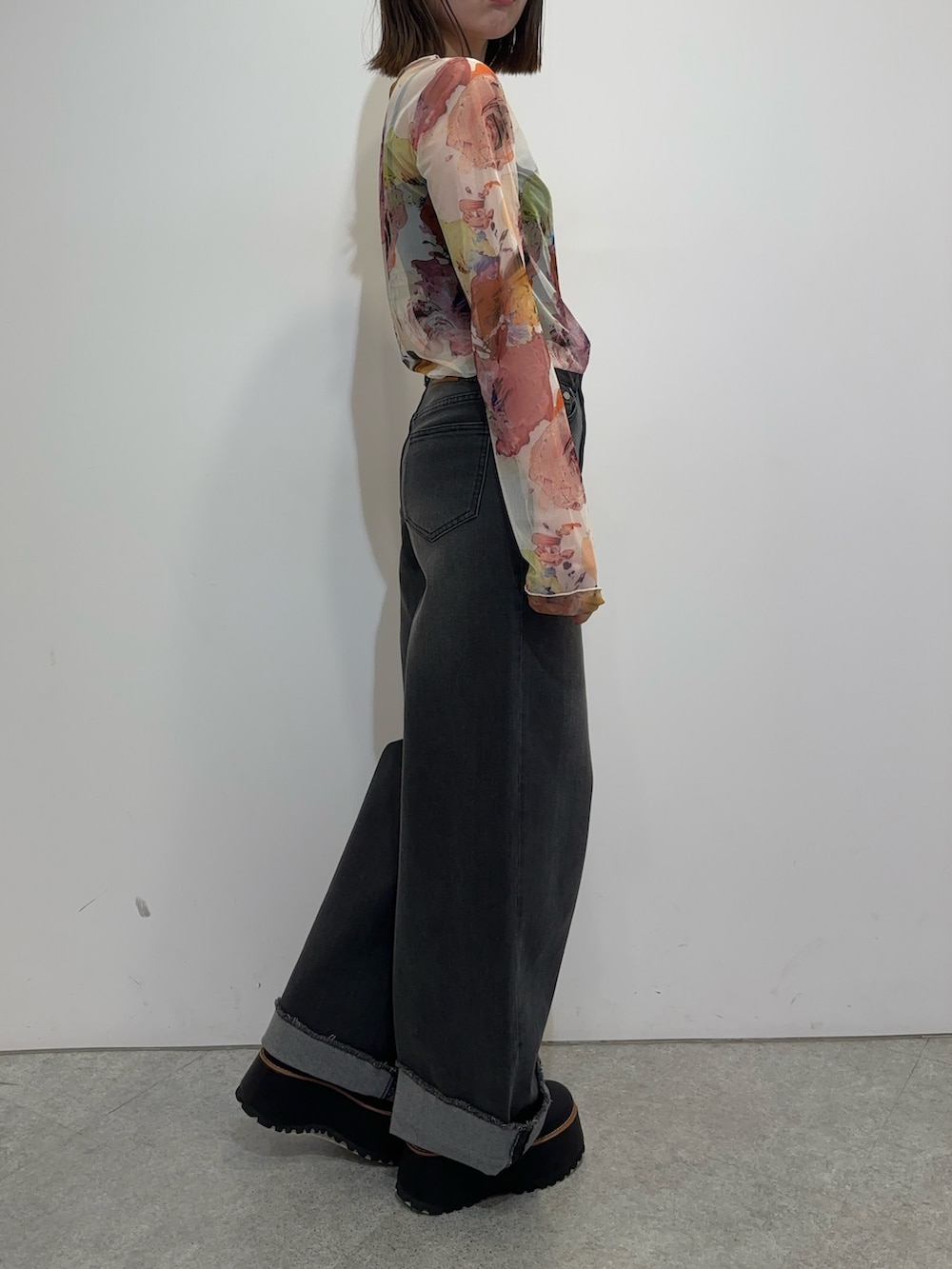 ホワイト系のTシャツ/カットソー、グレー系のデニムパンツ、ブラック系のブーツを着用したレディースの夏コーディネートの2枚目の写真