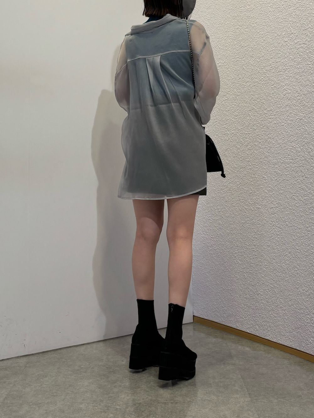 グレー系のスカート、ブラック系のショルダーバッグ、グレー系のシャツ/ブラウスを着用したレディースの春コーディネートの3枚目の写真