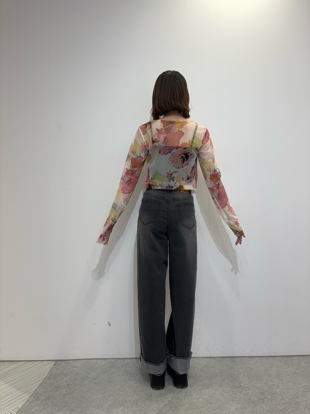 ホワイト系のTシャツ/カットソー、グレー系のデニムパンツ、ブラック系のブーツを着用したレディースの夏コーディネートの3枚目の写真