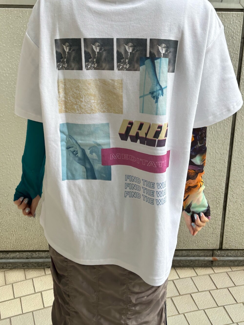 グレー系のスカート、ホワイト系のTシャツ/カットソー、ゴールド系のネックレスを着用したレディースの春コーディネートの3枚目の写真