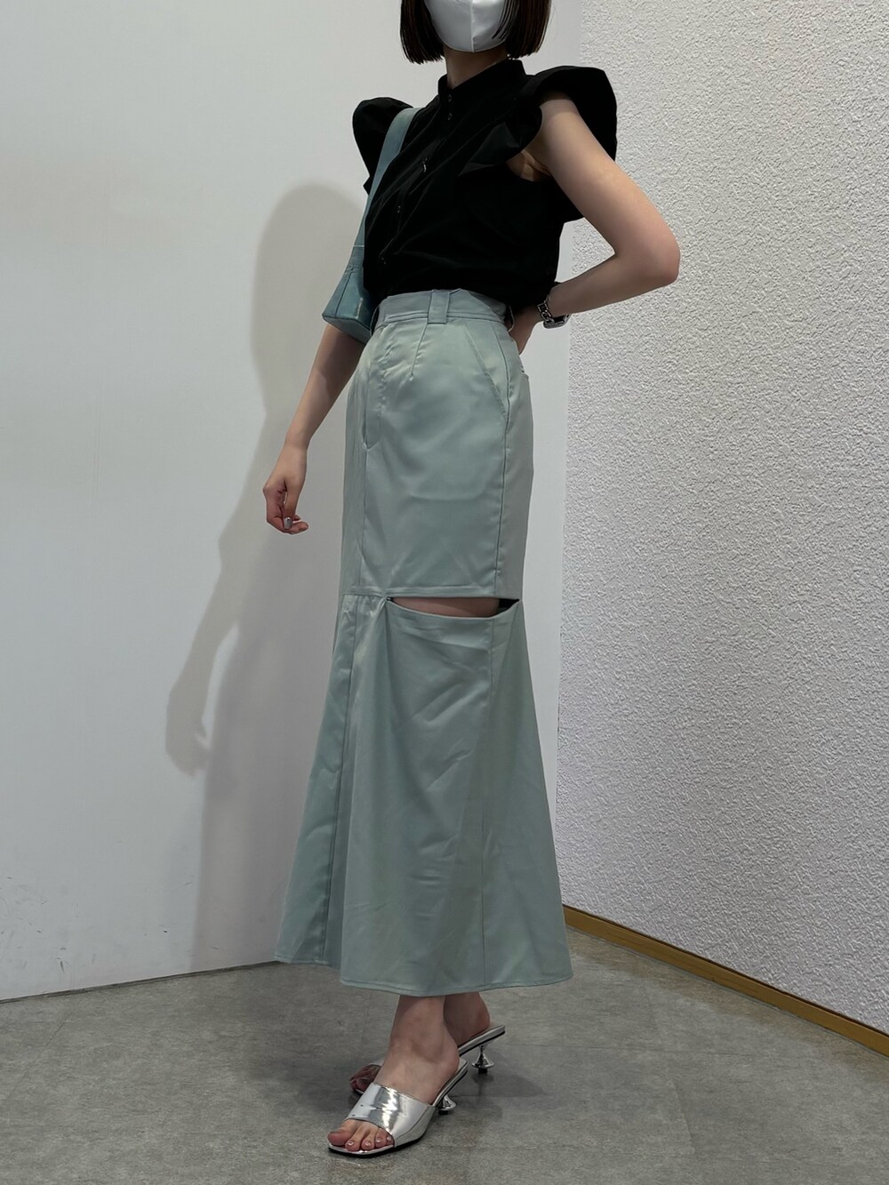 グリーン系のスカート、ブルー系のショルダーバッグ、シルバー系のサンダルを着用したレディースの春コーディネートの2枚目の写真