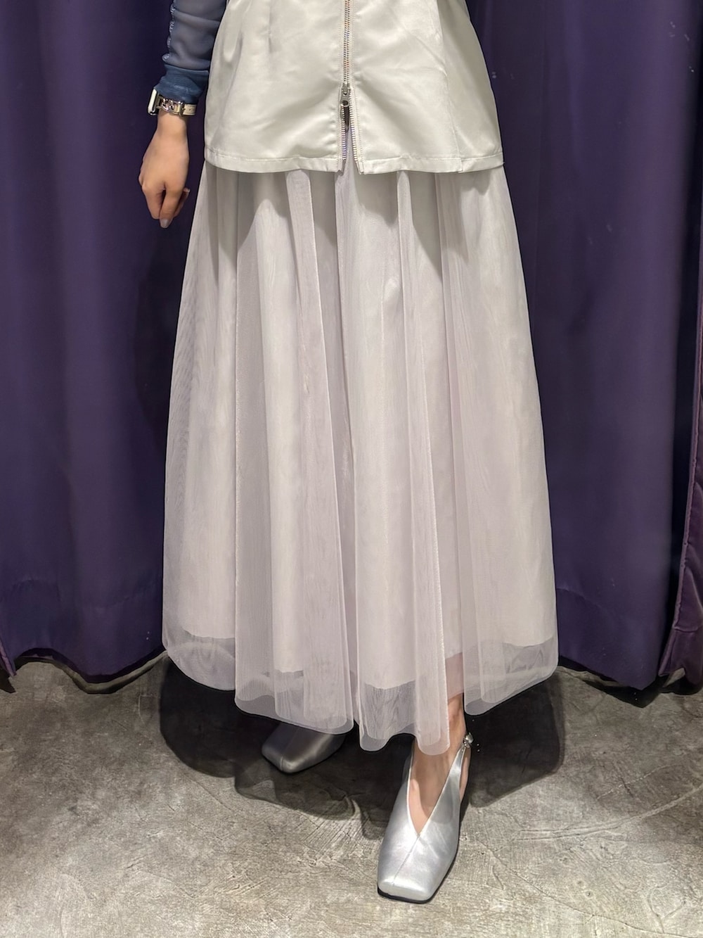 ホワイト系のジャンパースカート、グリーン系のTシャツ/カットソー、シルバー系のパンプスを着用したレディースの春コーディネートの4枚目の写真