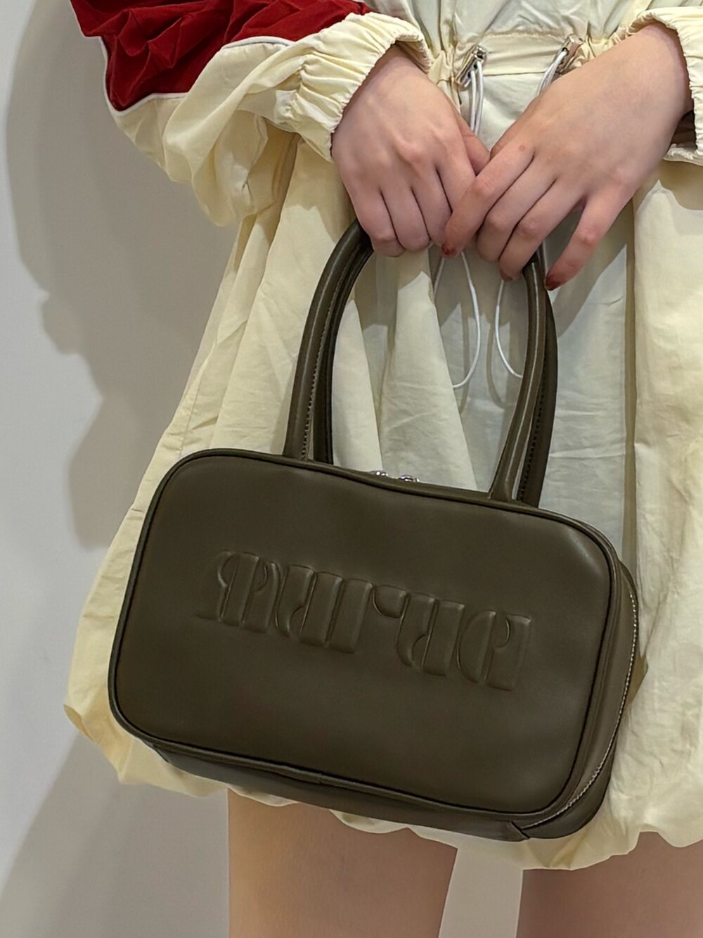 レッド系のワンピース、ブラウン系のブーツ、ブラウン系のボストンバッグを着用したレディースの夏コーディネートの6枚目の写真