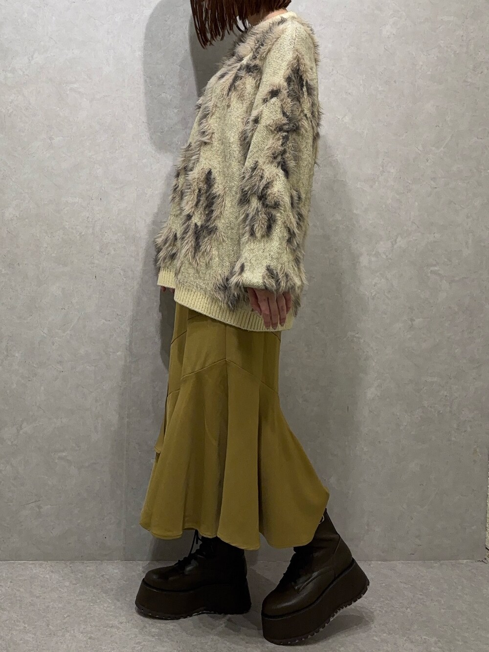 ホワイト系のニット/セーター、イエロー系のスカート、ブラウン系のブーツを着用したレディースの秋コーディネートの2枚目の写真