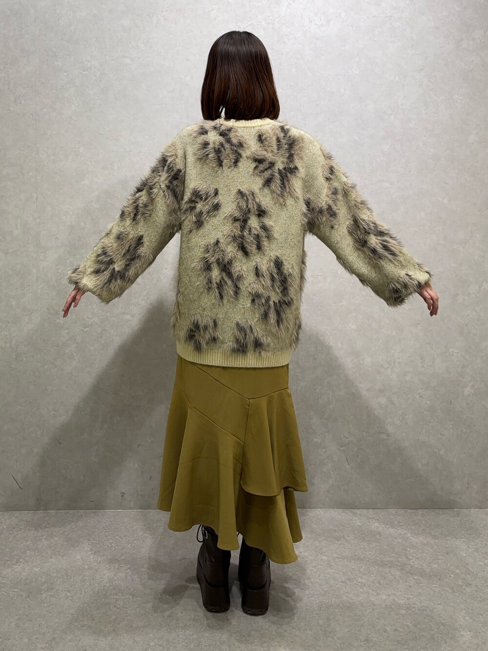 ホワイト系のニット/セーター、イエロー系のスカート、ブラウン系のブーツを着用したレディースの秋コーディネートの4枚目の写真