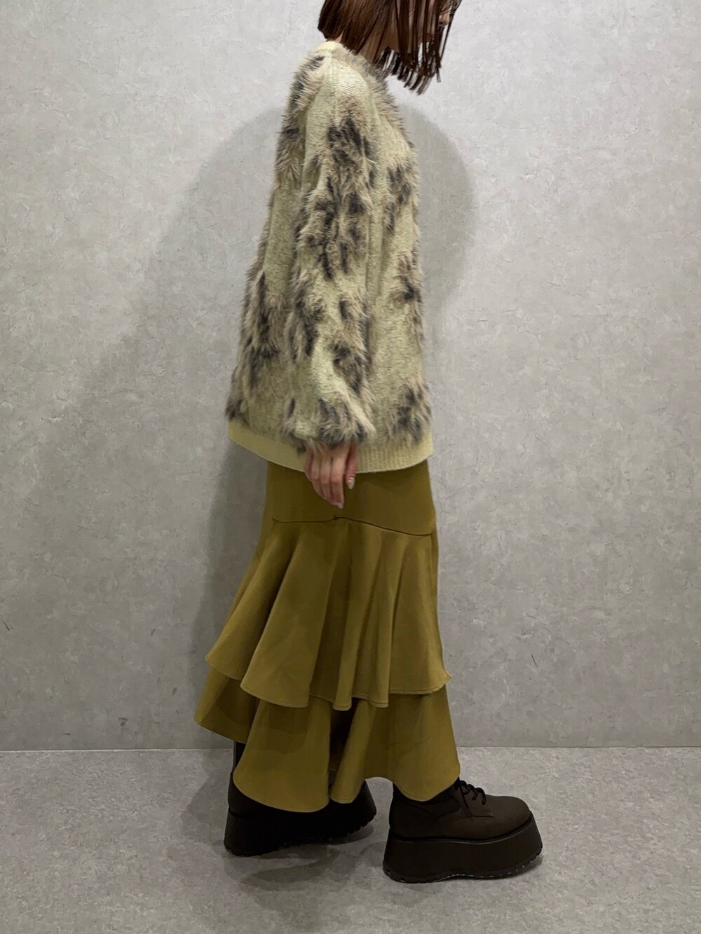 ホワイト系のニット/セーター、イエロー系のスカート、ブラウン系のブーツを着用したレディースの秋コーディネートの3枚目の写真