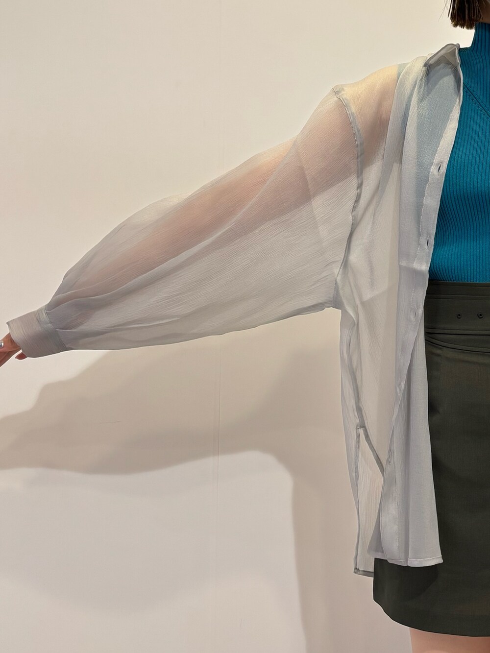 グレー系のスカート、ブラック系のショルダーバッグ、グレー系のシャツ/ブラウスを着用したレディースの春コーディネートの4枚目の写真