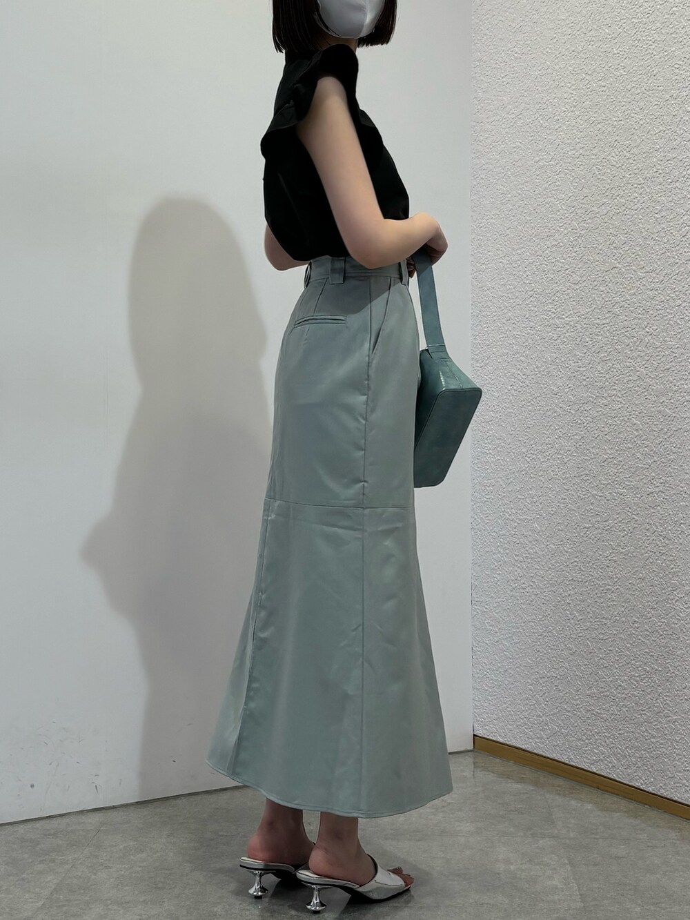 グリーン系のスカート、ブルー系のショルダーバッグ、シルバー系のサンダルを着用したレディースの春コーディネートの3枚目の写真