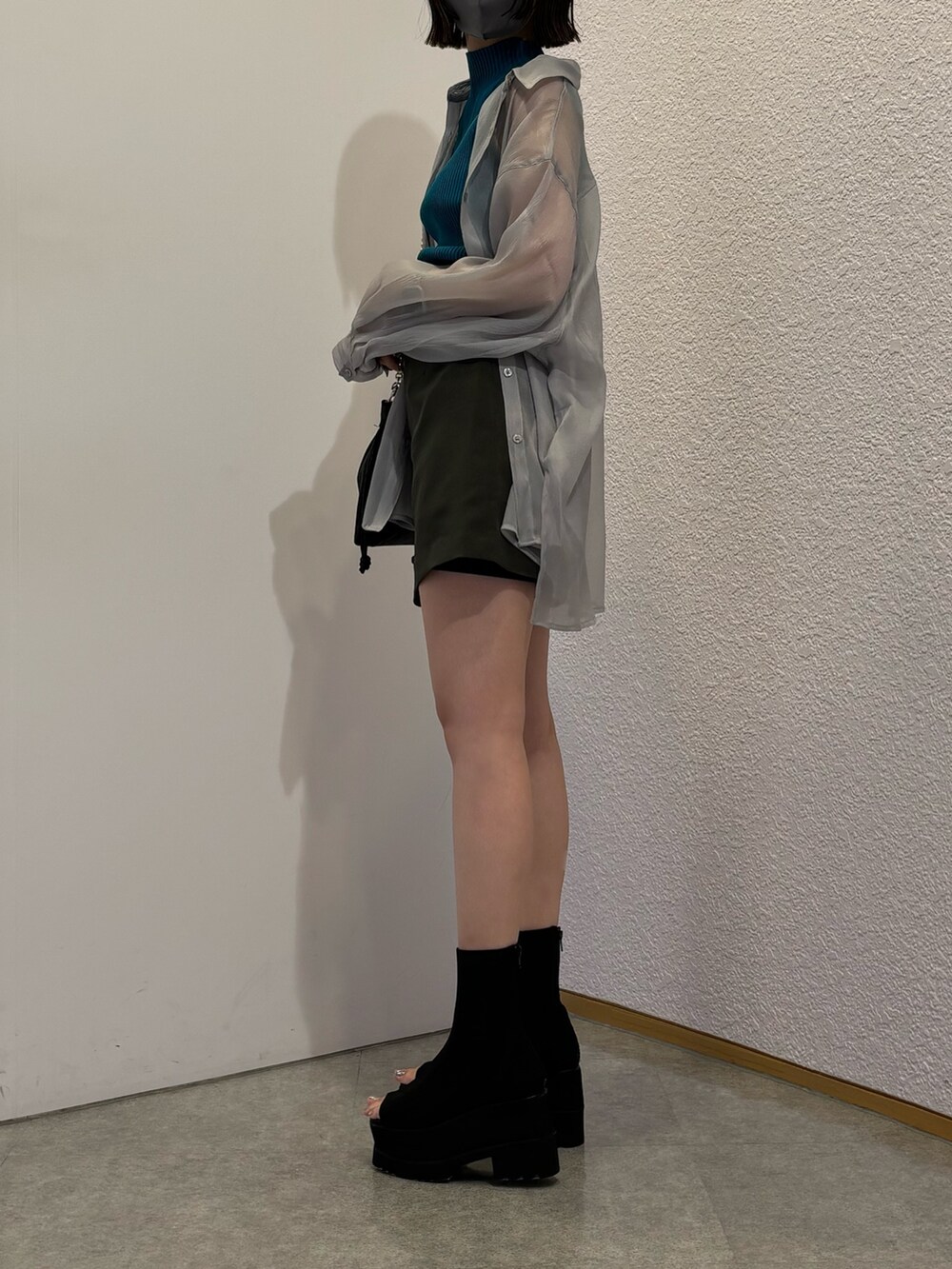 グレー系のスカート、ブラック系のショルダーバッグ、グレー系のシャツ/ブラウスを着用したレディースの春コーディネートの2枚目の写真