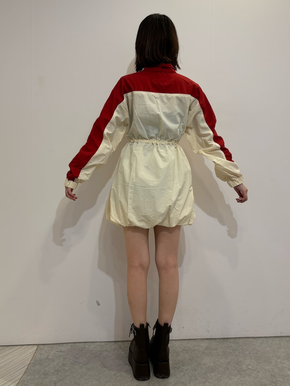 レッド系のワンピース、ブラウン系のブーツ、ブラウン系のボストンバッグを着用したレディースの夏コーディネートの4枚目の写真