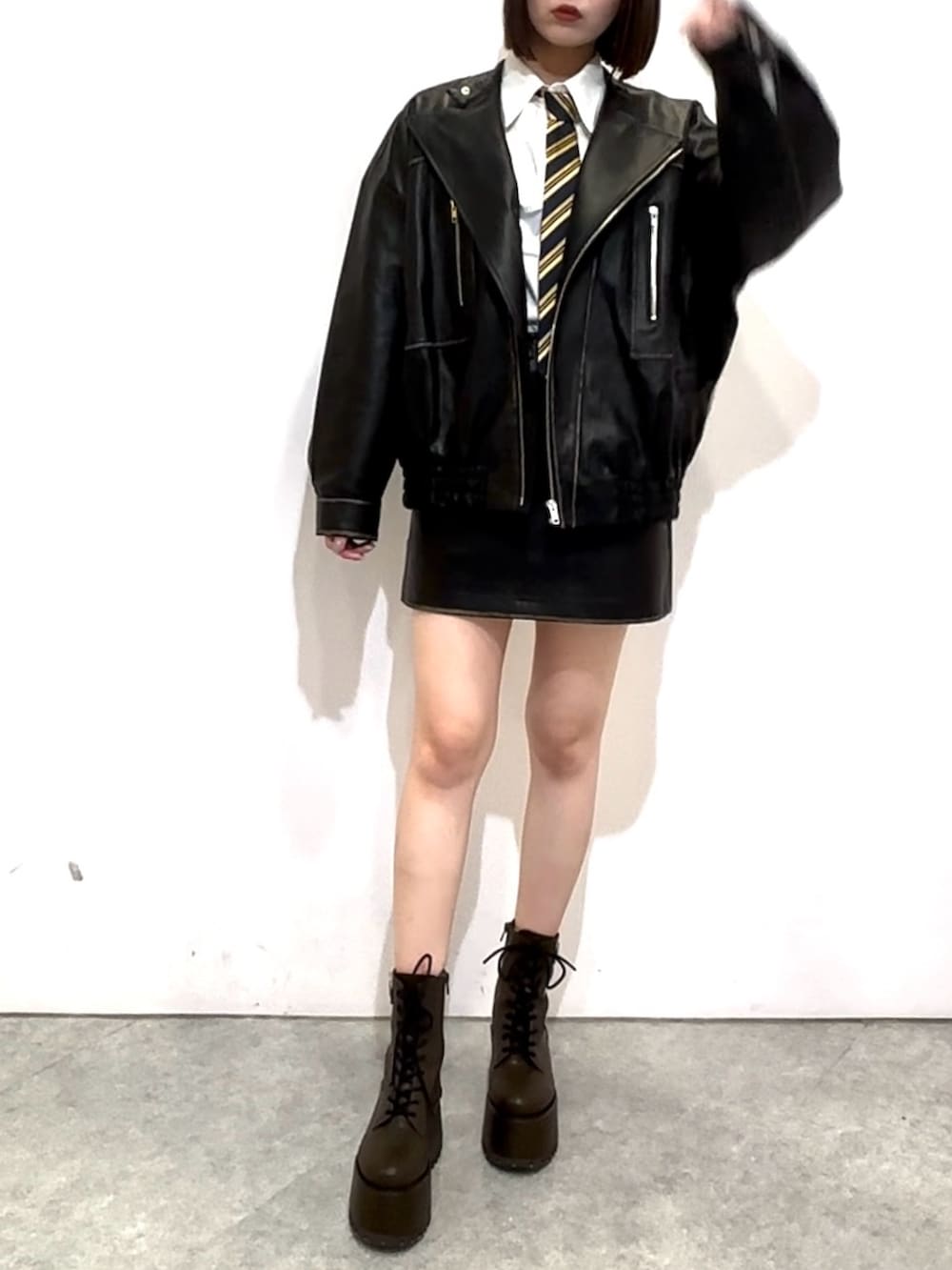 ブラック系のスカート、ホワイト系のシャツ/ブラウス、ブルー系のネクタイを着用したレディースの秋コーディネートの2枚目の写真