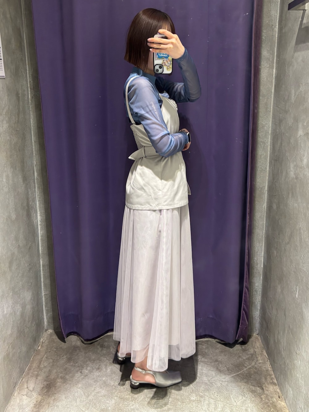 ホワイト系のジャンパースカート、グリーン系のTシャツ/カットソー、シルバー系のパンプスを着用したレディースの春コーディネートの2枚目の写真