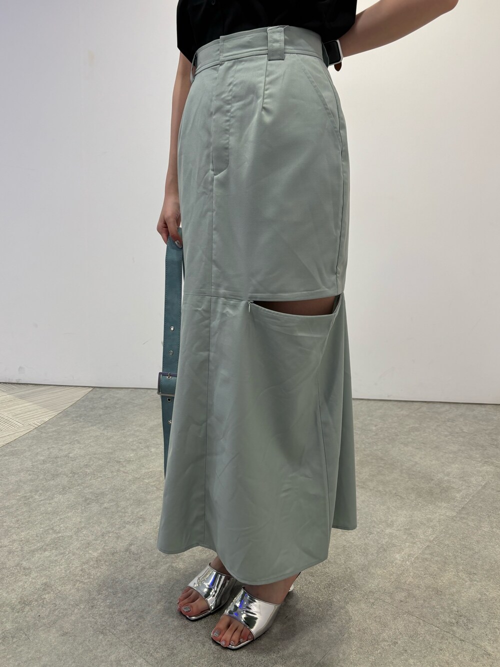 グリーン系のスカート、ブルー系のショルダーバッグ、シルバー系のサンダルを着用したレディースの春コーディネートの7枚目の写真