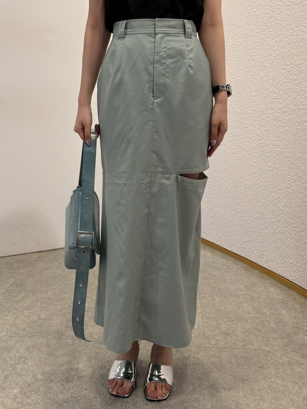 グリーン系のスカート、ブルー系のショルダーバッグ、シルバー系のサンダルを着用したレディースの春コーディネートの6枚目の写真