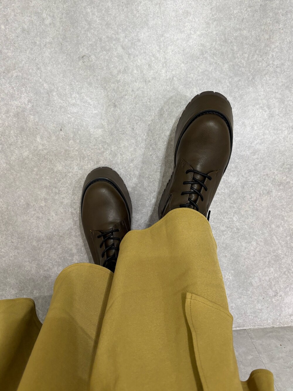 ホワイト系のニット/セーター、イエロー系のスカート、ブラウン系のブーツを着用したレディースの秋コーディネートの6枚目の写真