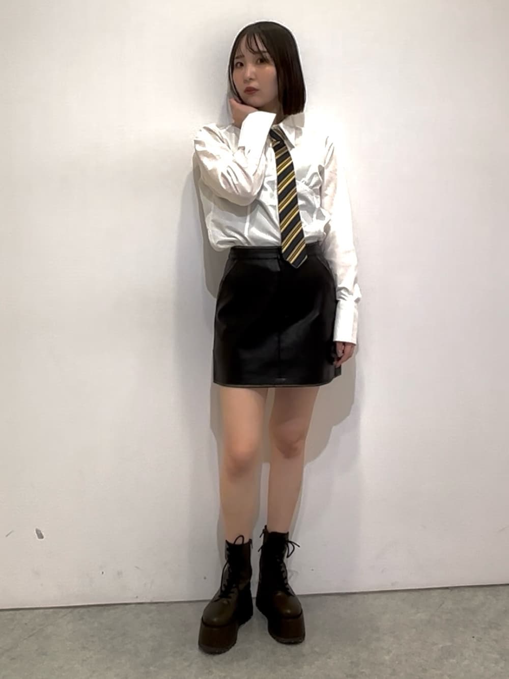 ブラック系のスカート、ホワイト系のシャツ/ブラウス、ブルー系のネクタイを着用したレディースの秋コーディネートの6枚目の写真