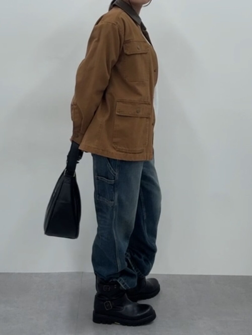 ブラウン系のジャケット/アウター、ベージュ系のTシャツ/カットソー、ブラック系のブーツを着用したレディースの秋コーディネートの5枚目の写真