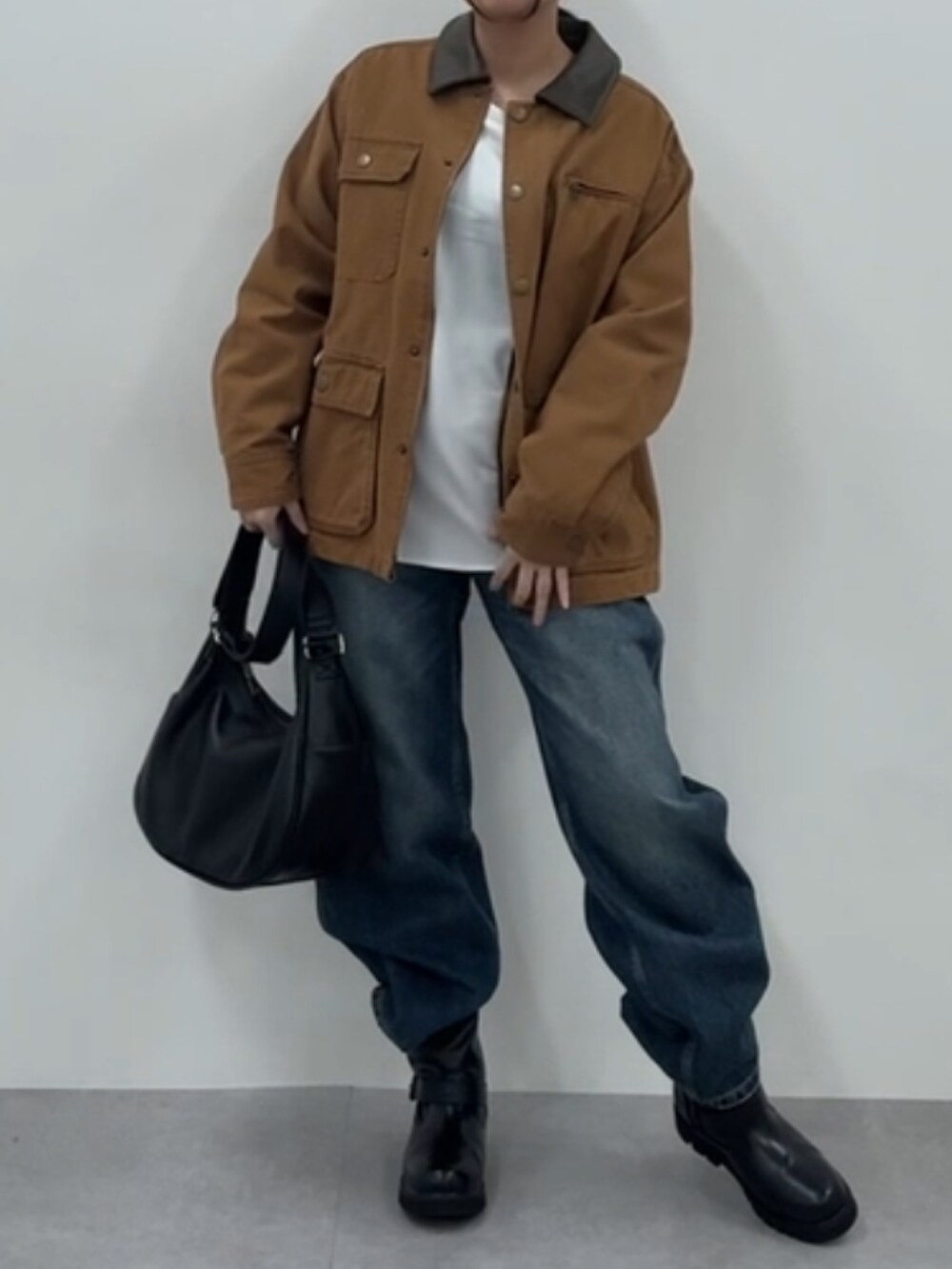 ブラウン系のジャケット/アウター、ベージュ系のTシャツ/カットソー、ブラック系のブーツを着用したレディースの秋コーディネートの2枚目の写真