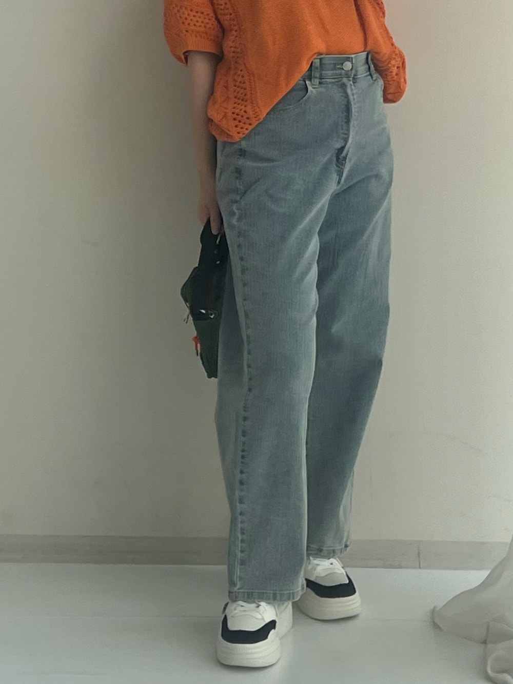 ブルー系のその他パンツ、ブラック系のスニーカー、グレー系のニット/セーターを着用したレディースの春コーディネートの3枚目の写真