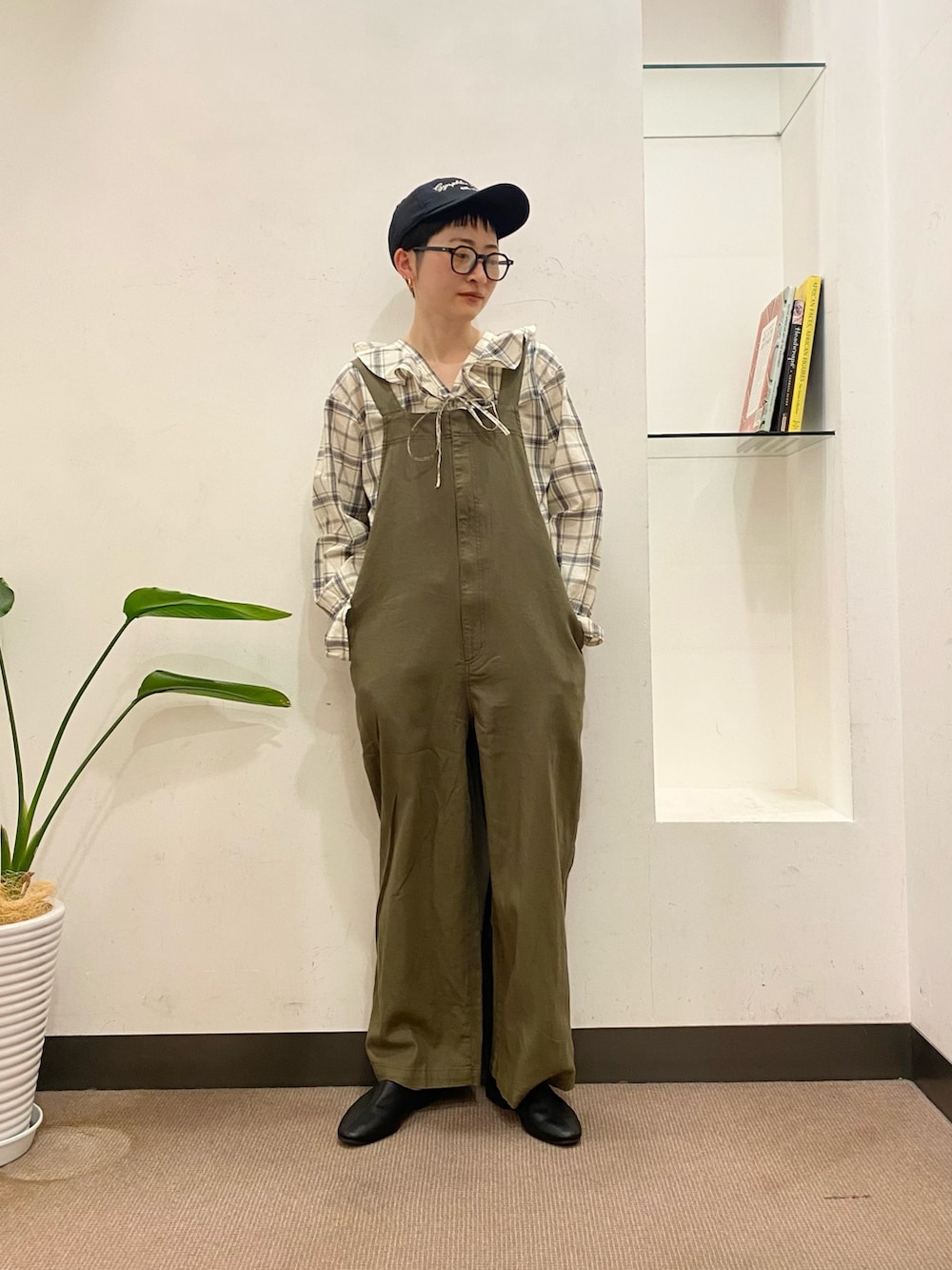 グリーン系のオールインワン・サロペット、ブラック系のシャツ/ブラウス、ブラック系のその他シューズを着用したレディースの春コーディネートの3枚目の写真