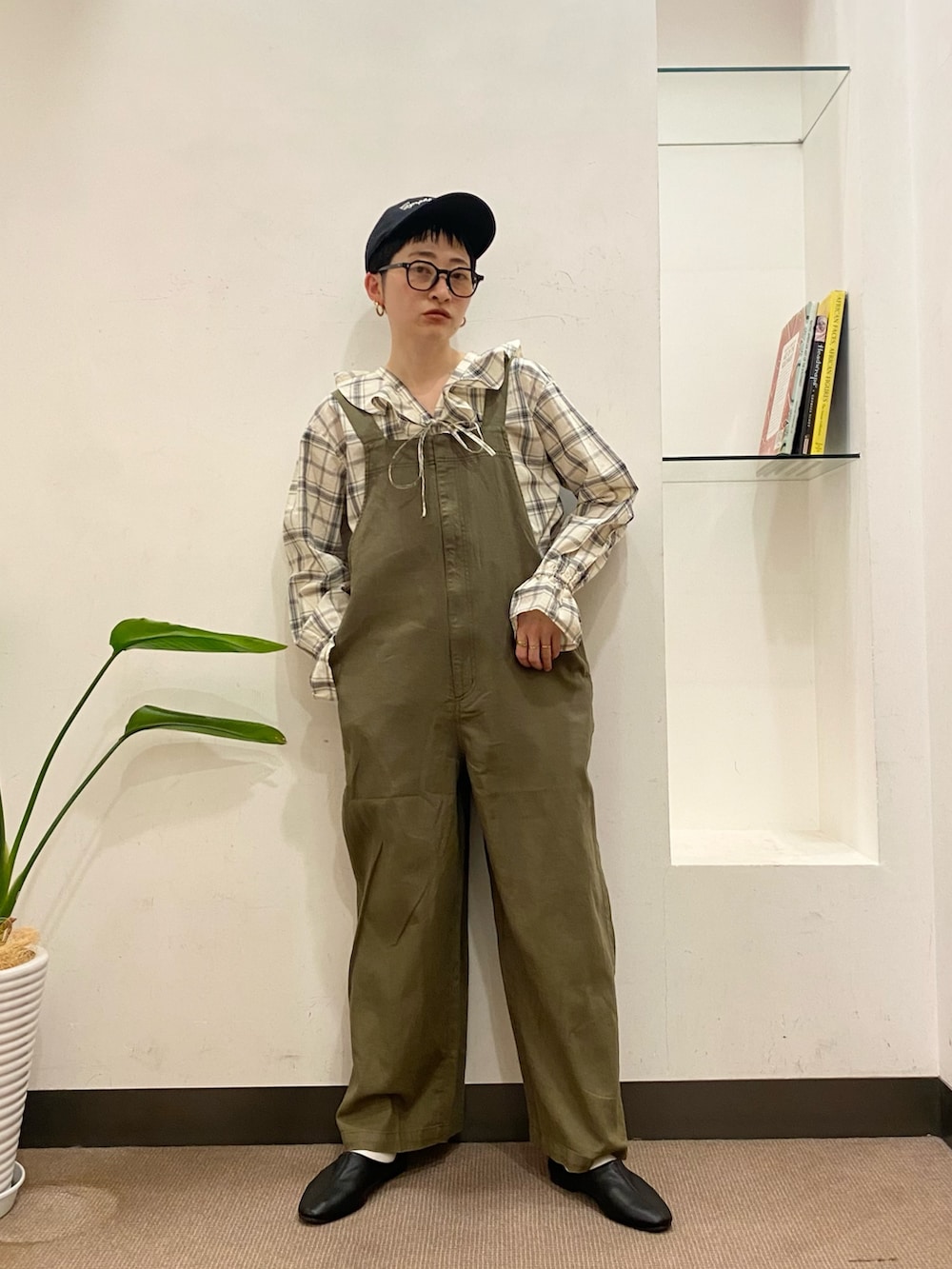 グリーン系のオールインワン・サロペット、ブラック系のシャツ/ブラウス、ブラック系のその他シューズを着用したレディースの春コーディネートの2枚目の写真