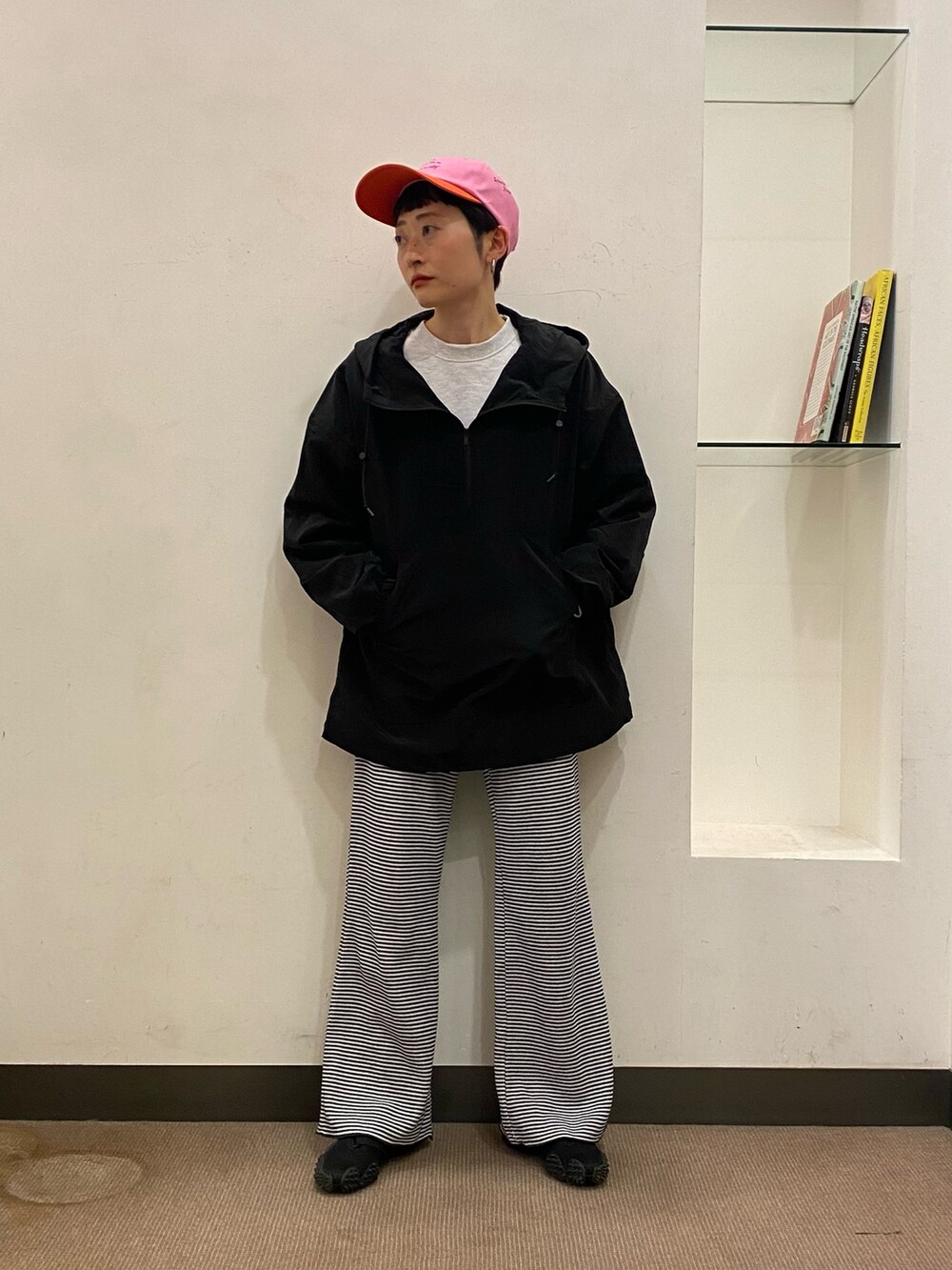 ブラック系のトップス、ブルー系のパンツ、ピンク系のキャップを着用したレディースの冬コーディネートの3枚目の写真