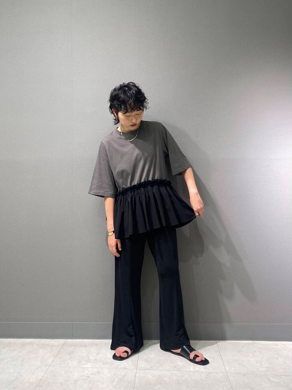 ブラック系のサンダル、ブラック系のその他パンツ、グレー系のTシャツ/カットソーを着用したレディースの夏コーディネートの2枚目の写真