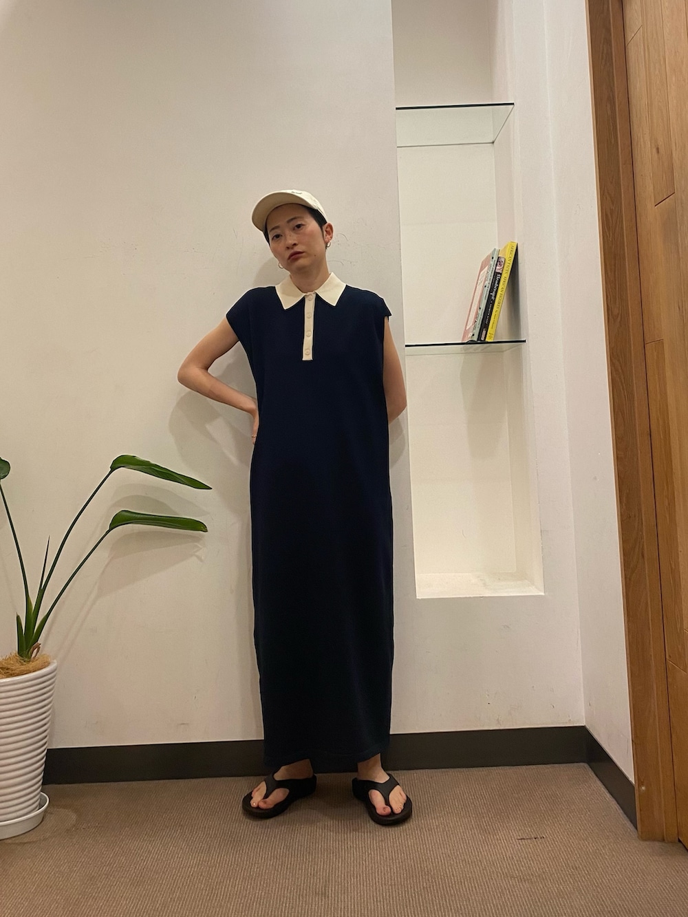 ブルー系のワンピース、ブラック系のサンダル、ホワイト系のキャップを着用したレディースの夏コーディネートの2枚目の写真