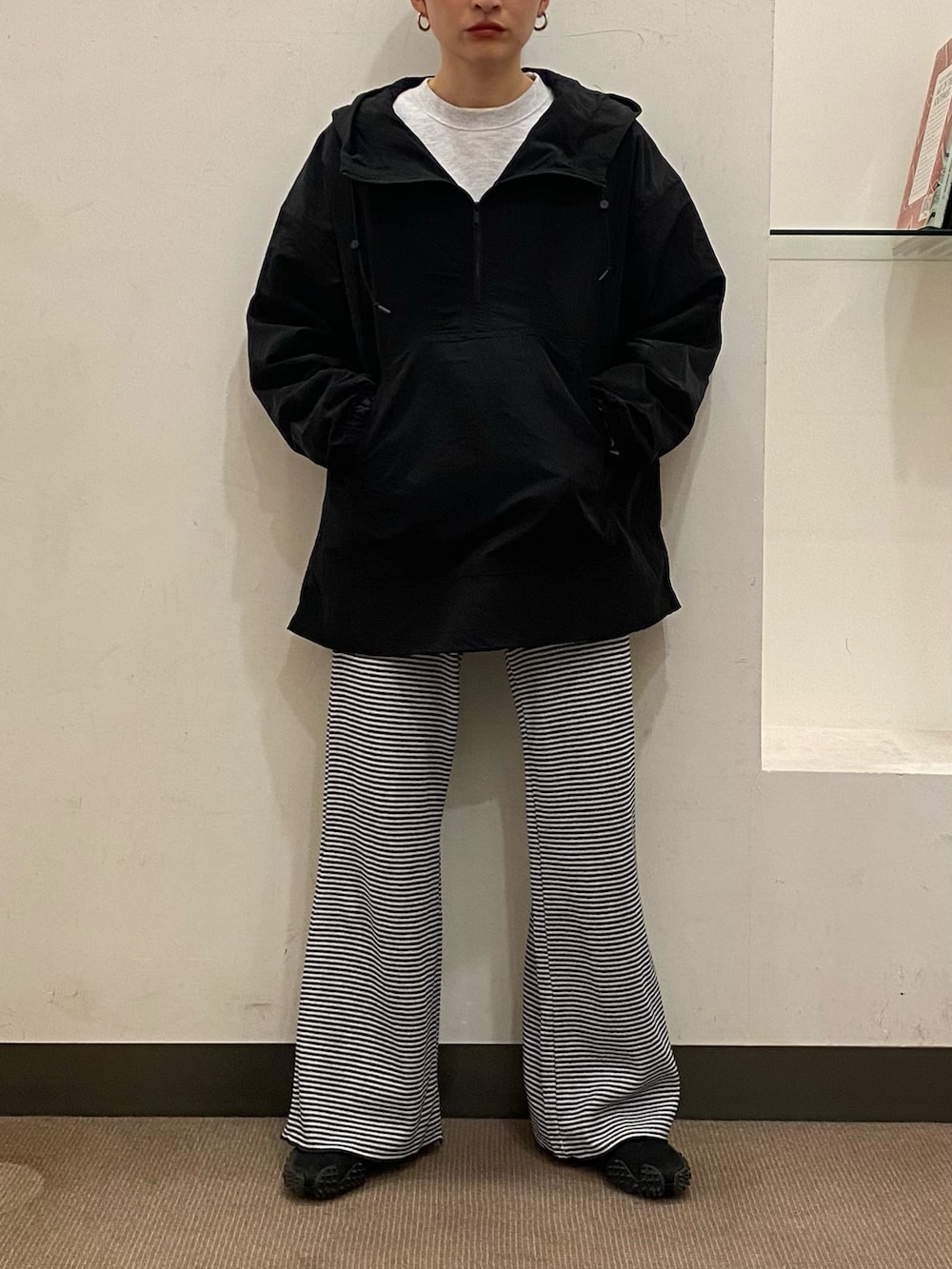 ブラック系のトップス、ブルー系のパンツ、ピンク系のキャップを着用したレディースの冬コーディネートの2枚目の写真