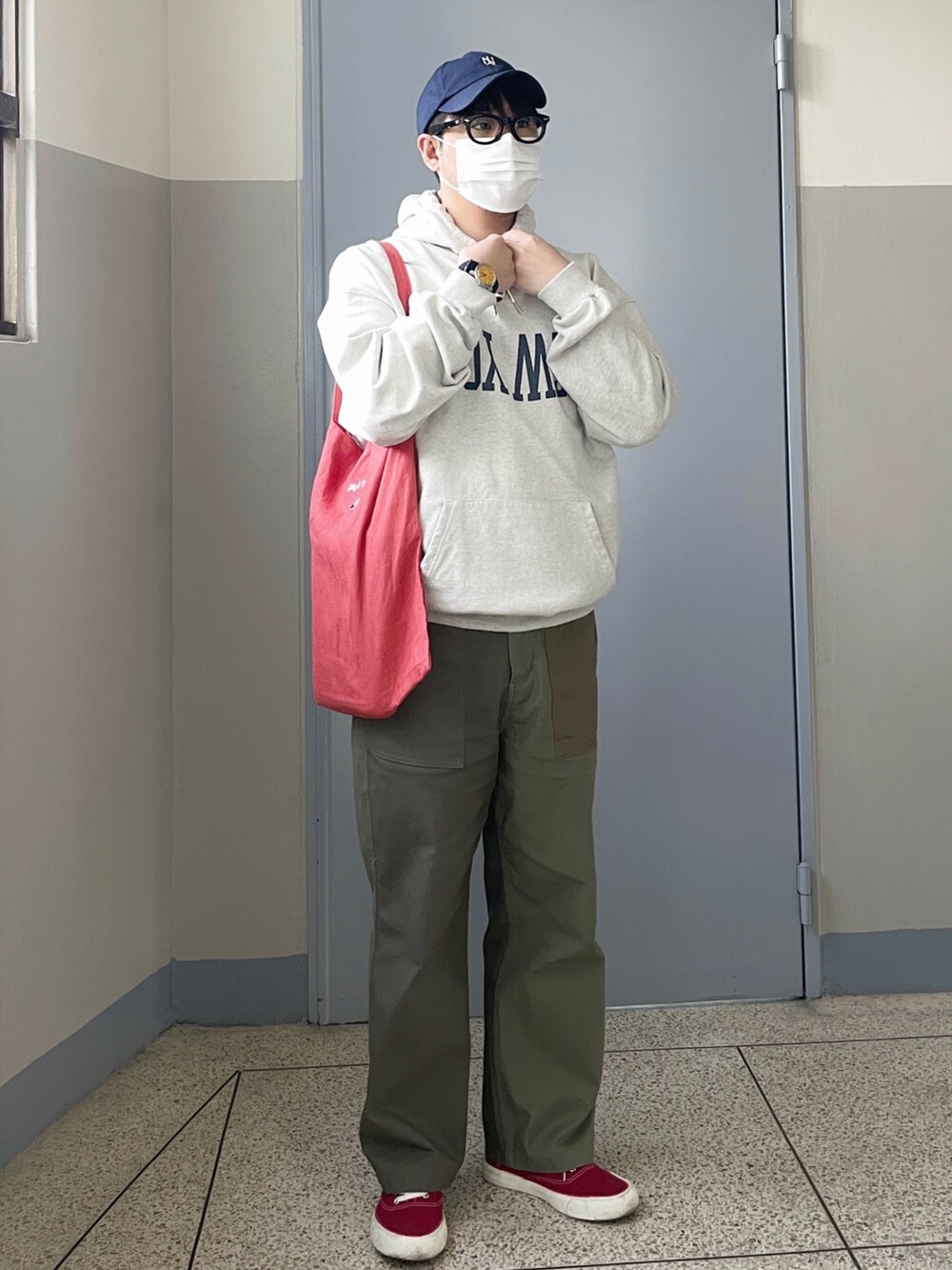 グレー系のパーカー、グリーン系のチノパンツ、レッド系のスニーカーを着用したメンズの春コーディネートの2枚目の写真