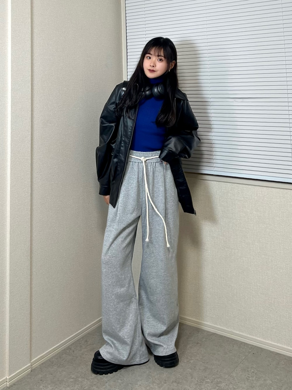 ブルー系のニット/セーター、ブラック系のブルゾン、グレー系のその他パンツを着用したレディースの冬コーディネートの2枚目の写真