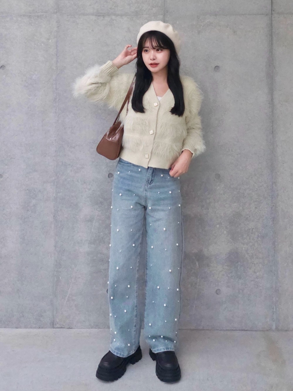 ベージュ系のカーディガン/ボレロ、ブルー系のデニムパンツ、ブラウン系のボストンバッグを着用したレディースの秋コーディネートの2枚目の写真