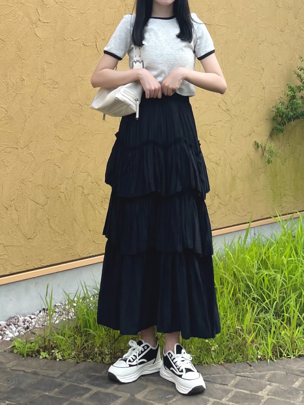 グレー系のTシャツ/カットソー、ブラック系のスカート、ホワイト系のショルダーバッグを着用したレディースの夏コーディネートの3枚目の写真