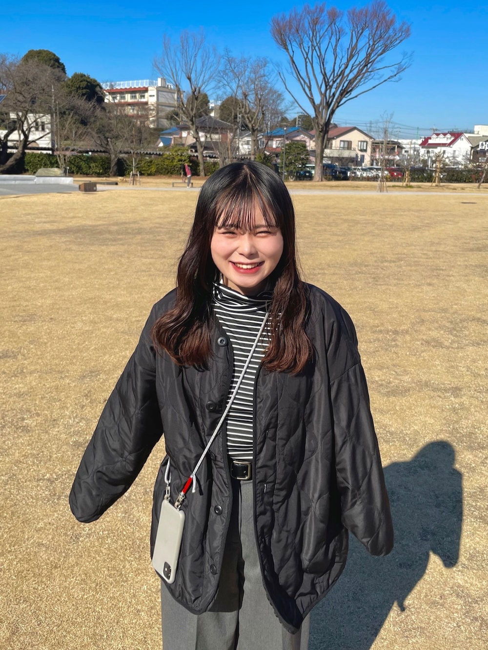 グレー系のスラックス、ブラック系のブーツ、ブラック系のノーカラージャケットを着用したレディースの冬コーディネートの3枚目の写真