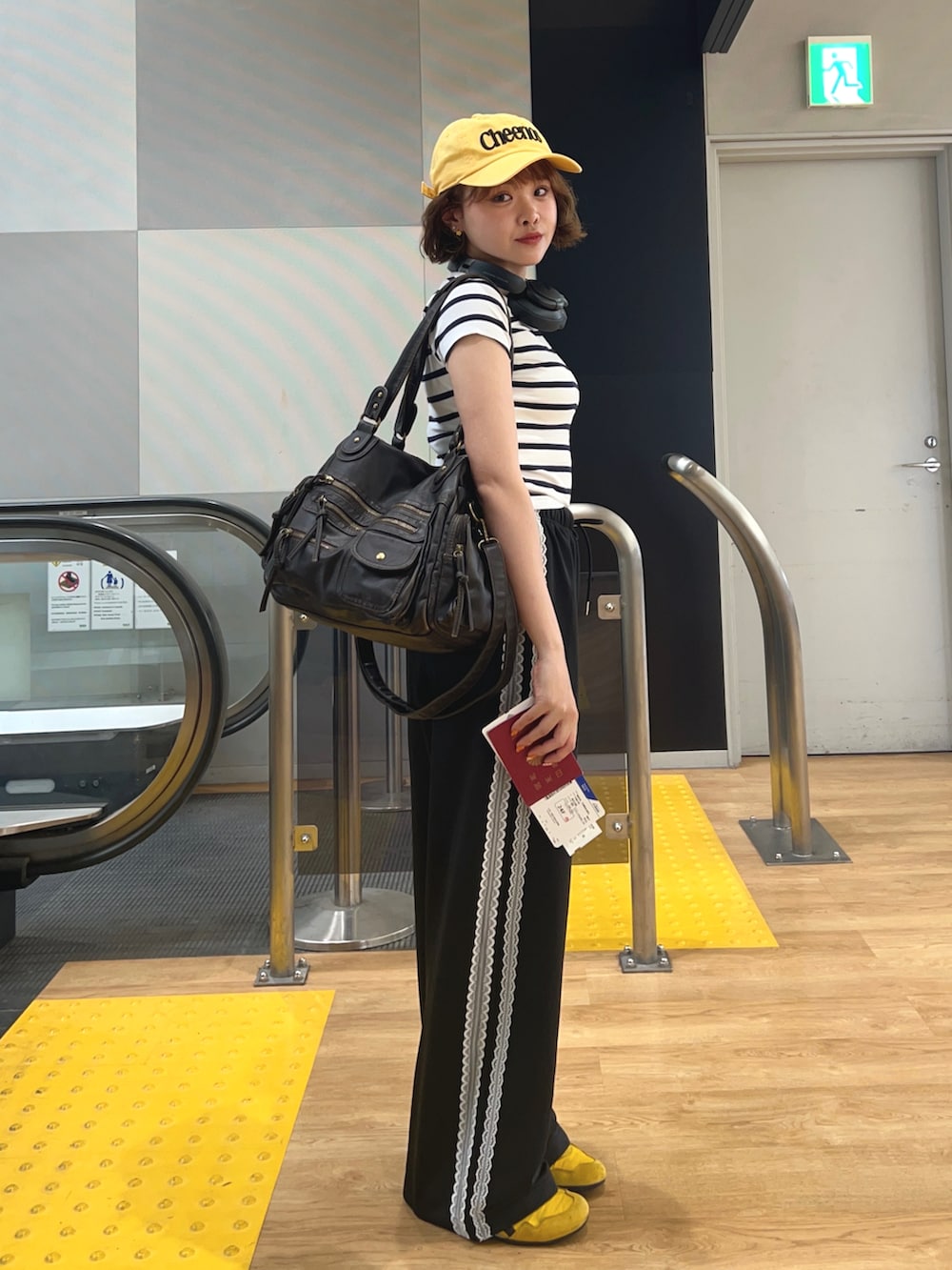 ブラック系のその他パンツ、イエロー系のスニーカー、ホワイト系のTシャツ/カットソーを着用したレディースの秋コーディネートの2枚目の写真